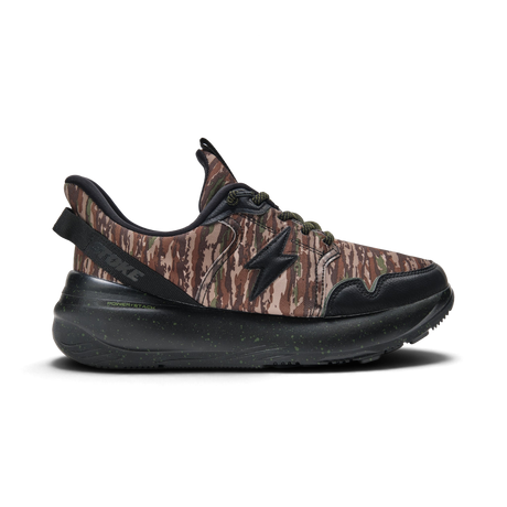 A single low-top sneaker shown in a side profile on a clean white background. The upper features a brown and beige camouflage pattern with black overlays, a black star-shaped side logo, and a thick black speckled sole.