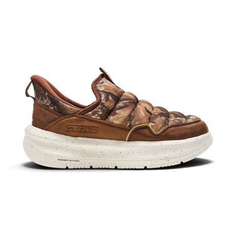 A single Stoke brand slip-on shoe with a brown and camouflage pattern upper, brown suede overlays, and a thick speckled off-white sole, shown against a plain white background.